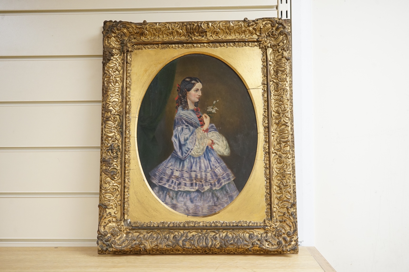 19th century, Naïve school, oval oil on board, three quarter length portrait of a lady, gilt framed, together with a similar portrait of a girl wearing garnet earrings, largest 34 x 24cm